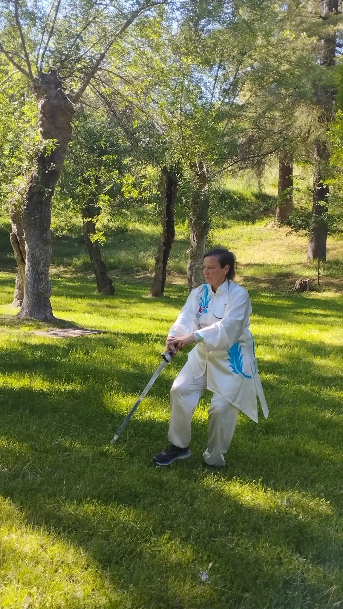 Maite García con espada de Tai Chi en jardín